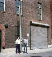 two volunteers holding up a 16-foot pipe