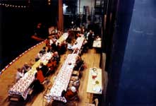 Photo of a view of a Christmas potluck dinner on stage at the Emery