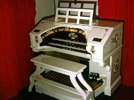 Photo of 2 manual console with red curtins around it.