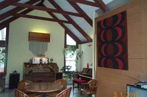 Photo of music room with console, piano, and pipe chamber on right