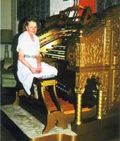 Photo of Joan Strader sitting at the Wurlitzer organ console.